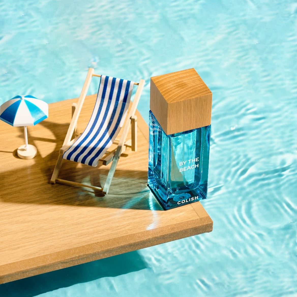 Colish By the Beach perfume styled with a miniature deckchair beside a pool